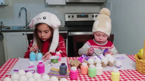 Focused children with easter bunny ears decorate and color eggs. Stock Footage 233103709