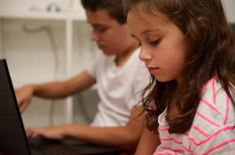 Focused children using laptops for online learning at home Stock Photos