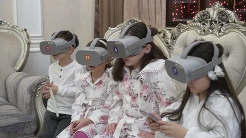 Focused children in a virtual reality headset on a holiday. 스톡 동영상 230285815
