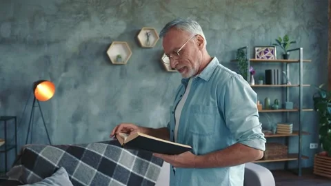 Focused clever middle aged man read published story think go in room apartment Stock Footage 166624566