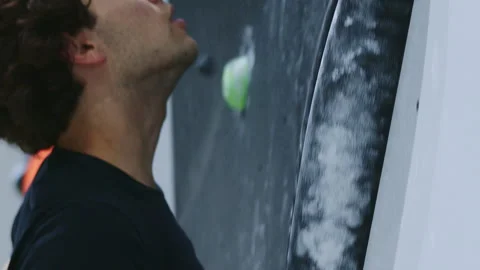 Focused Climber with Chalk-Dusted Hands Gripping Large Hold on Indoor Climbing Stock Footage 276968740