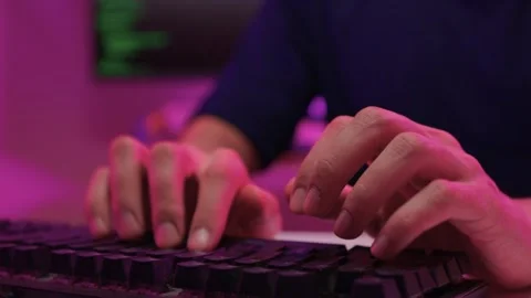 Focused coding session. Hands dash across keys with vibrant illumination Stock-Footage 347874546