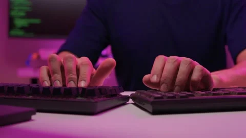 Focused coding session. Hands dash across keys with vibrant illumination Stock-Footage 347874561