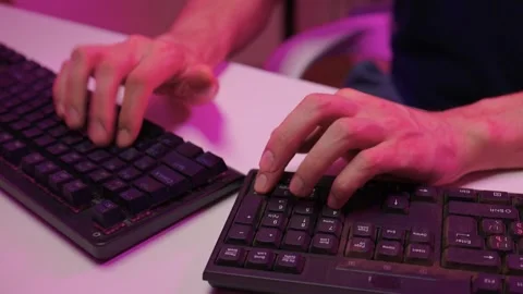 Focused coding session. Hands dash across keys with vibrant illumination Stock-Footage 347874583