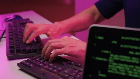 Focused coding session. Hands dash across keys with vibrant illumination Stock-Footage 347874600