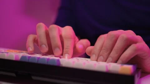 Focused coding session. Hands dash across keys with vibrant illumination Stock Footage 347874691