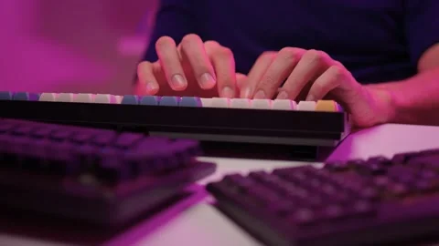 Focused coding session. Hands dash across keys with vibrant illumination Stock Footage 347874841