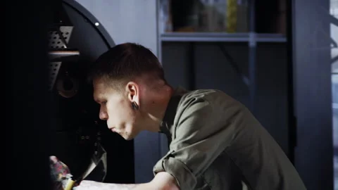 Focused Coffee Worker Cleans Roasting Machine After Use Stock Footage 307598118