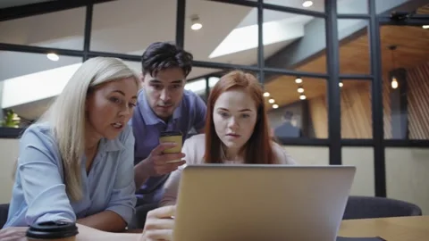 Focused colleagues using laptop in office Stock Footage 142060770