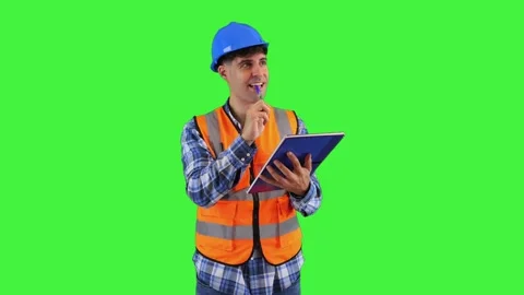 Focused construction engineer taking notes with pen in notebook, wearing or.. Stock Footage 286986012