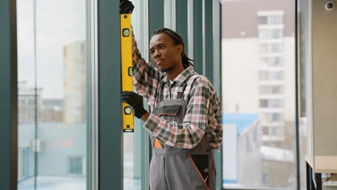 Focused construction worker leveling window frame Video stock 309484042