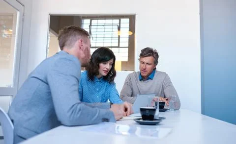 Focused coworkers using a digital tablet together in an office Stock Photos