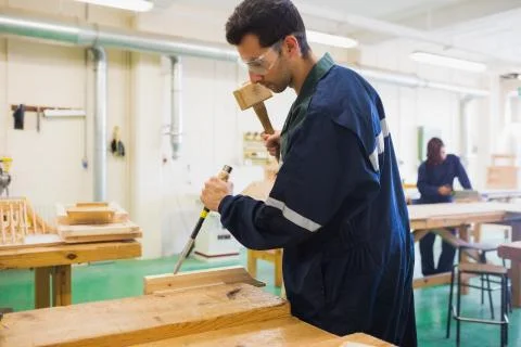 Focused craftsman using mallet and chisel Stock Photos