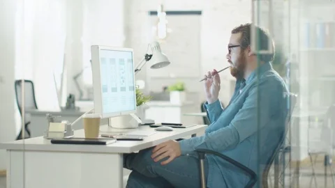Focused Creative Man Thinks while Sitting at His Workplace Desk.  Vídeos de archivo 70629751