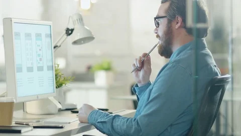 Focused Creative Man Thinks while Sitting at His Workplace Desk.  Vídeos de archivo 70630179
