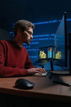 Focused data scientist writing code on keyboard in a dimly lit workspace. Stock Photos
