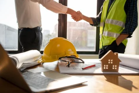 Focused at the desk. behind is Construction workers or architects and enginee Stock-Fotos