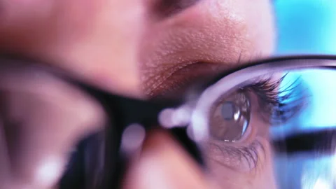 Focused Determination: Close-Up of Womans Glasses with Laptop Screen Reflection Stock Footage 319079270