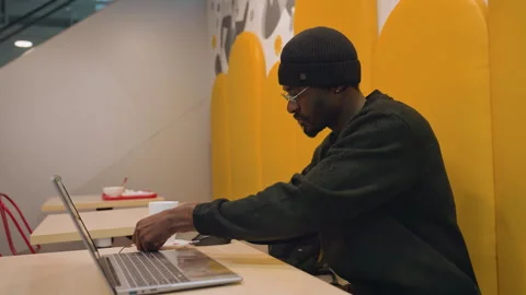 Focused developer debugging at cafe. African American male software developer Stock Footage 335322058