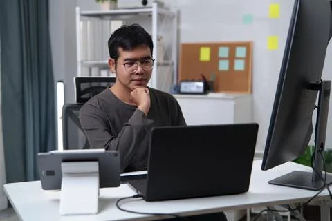 Focused Developer Engaged in Coding and Problem-Solving at a Workspace 스톡 사진
