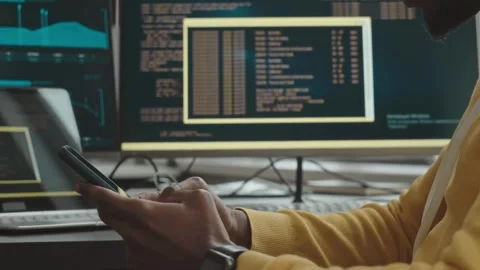 Focused Developer Switching Between Coding Tasks and Mobile Workflow Stock Footage 321985341