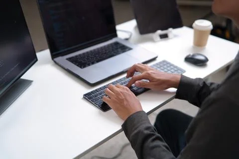 Focused Developer Working on Laptop and Desktop for Software Programming Foto stock