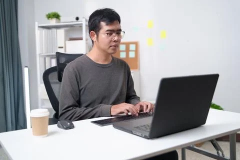Focused Developer Working on Laptop in Professional Office Environment Stock Photos