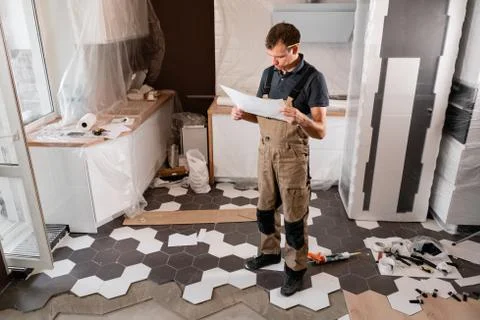 Focused diligent worker inspecting room and planning repairs work. repair of the Stock Photos