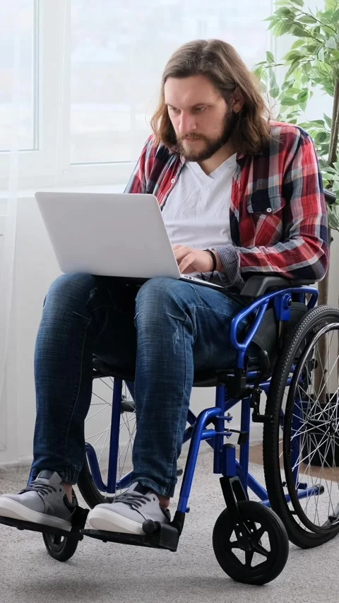 Focused Disabled Man in Wheelchair Working on Laptop at Home Stock Footage 328122851