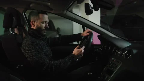 Focused driver messaging someone and nodding with approval. Brunette man with Stock Footage 233967713