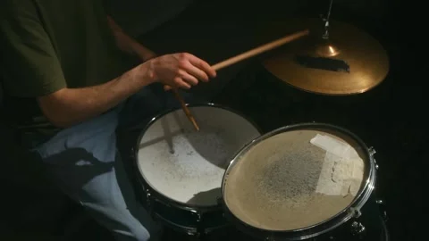A focused drummer refining skills in a dark space, highlighting dedication and Video stock 312845473