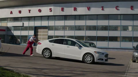 With focused effort man pushes vehicle along symbol of his commitment to Stockbeeldmateriaal 270953149