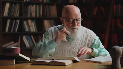 Focused elderly scientist underlining information in book, deep research work Stock Footage 320670657