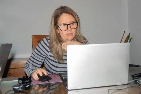 Focused employee working from home using laptop and mouse Stock Photos