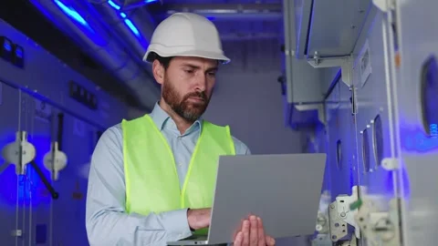 Focused engineer in electrical room manages power systems and operator station. Stock Footage 256288757