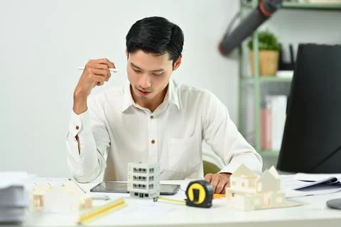 Focused engineer man using digital tablet, working on construction project of 스톡 사진