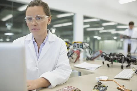 Focused engineer working at computer with robotics Stock Photos