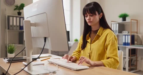 Focused female accountant working on computer with paperwork in modern office Stock Footage 340925426