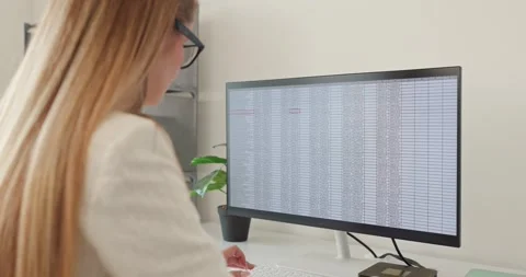 Focused female analyst working with spreadsheet data on widescreen monitor in Stock-Footage 345024784