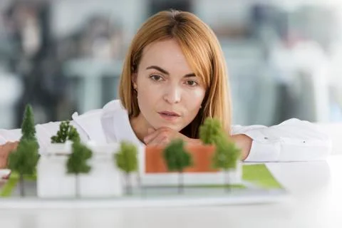 Focused female architect examining model Stock Photos