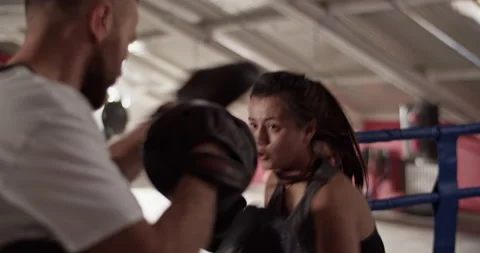Focused female boxer training with instructor Stock Footage 228439714