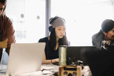 Focused female computer programmer coding at laptop in office Foto stock