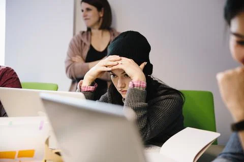 Focused female computer programmer coding at laptop in office Stock Photos