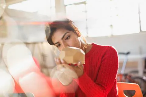 Focused female engineer examining prototype in sunny office Stock Photos