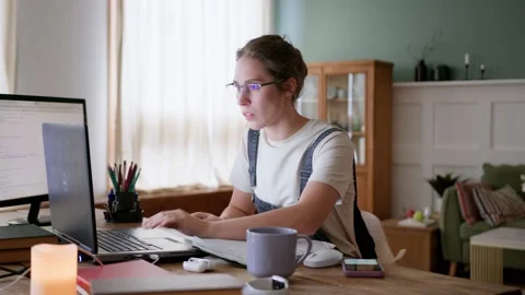 Focused female freelancer works multitasking on laptop in home office Stock Footage 196271704