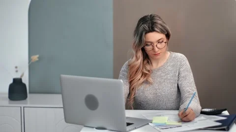 Focused female in glasses studying e learning use laptop writing notes. Shot Stock-Footage 151783203