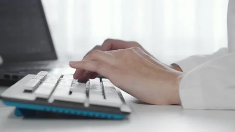 Focused female hands gracefully typing on a sleek computer keyboard Stock Footage 311488656