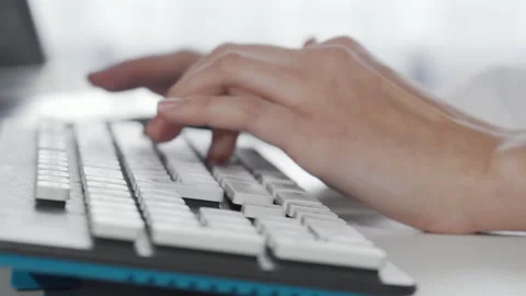 Focused female hands typing swiftly on a sleek computer keyboard Stock Footage 311536626