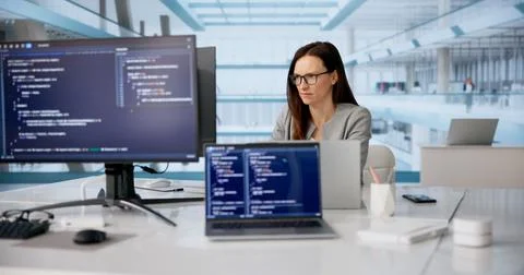 Focused Female Software Developer Coding On Laptop At Modern Workspace 스톡 사진