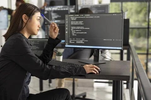 Focused Female Software Engineer at Computer Desk 库存照片